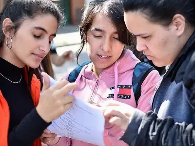 Tres estudiantes leen un guión en medio del rodaje de su corto